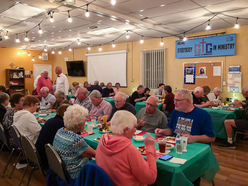 Tables of people enjoying eating Italian Dinner