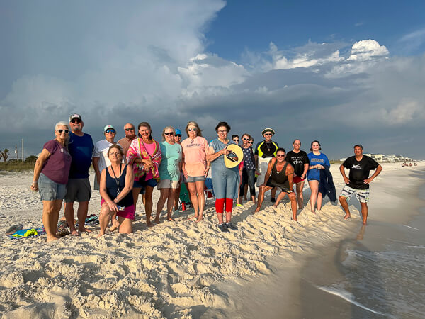 Large group of baptism participants and supporters at the beach