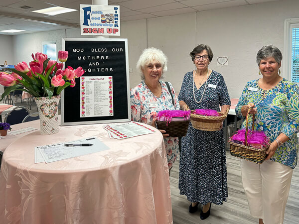 Three women with baskets of Mother's Day gifts