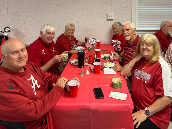 People sitting at a table decorated in red.