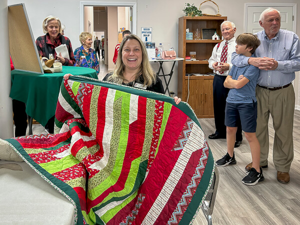 Katie happily holds a quilt given to her by Gulfview