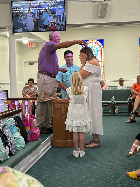 Young woman gets baptized during worship service.