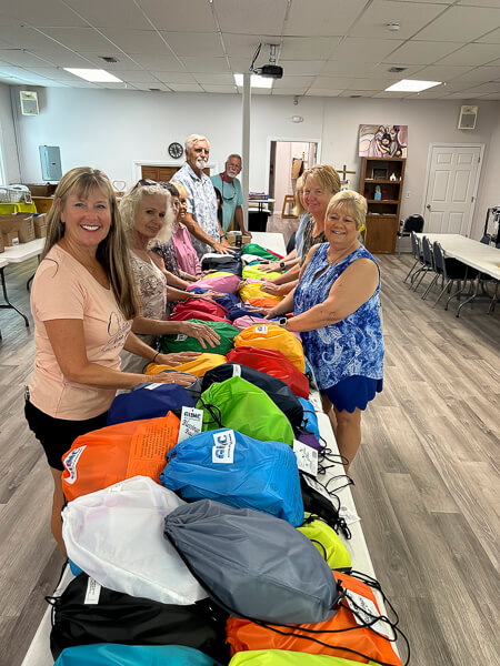 Group of people assemble bags of items for homeless people.