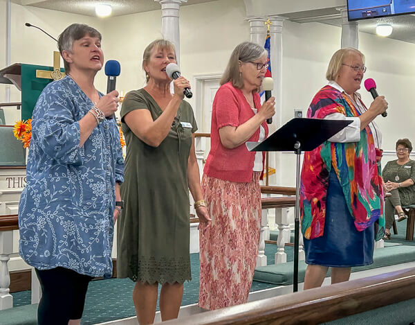 Four ladies sing together in worship service.