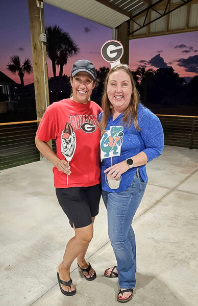 Georgia and Florida fans stand in front of the sunset sky