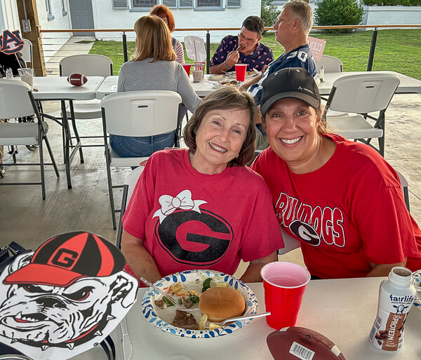 Two ladies wear University of Georgia apparel.