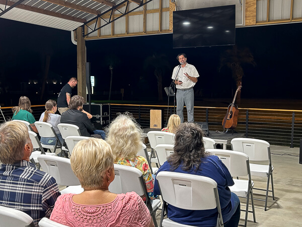 Man talks in pavilion at a night event