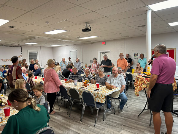 Pastor welcoming a crowd for Thanksgiving Dinner