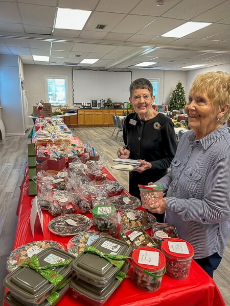 Two UWF members laughing over baked goods