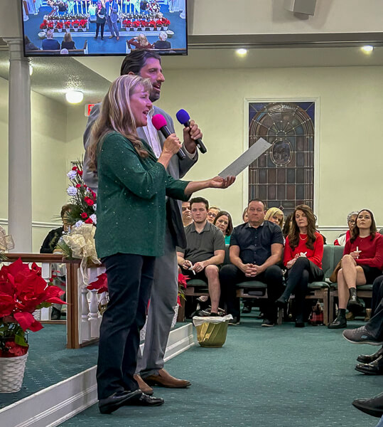 Man and woman sing during Christmas Eve service.