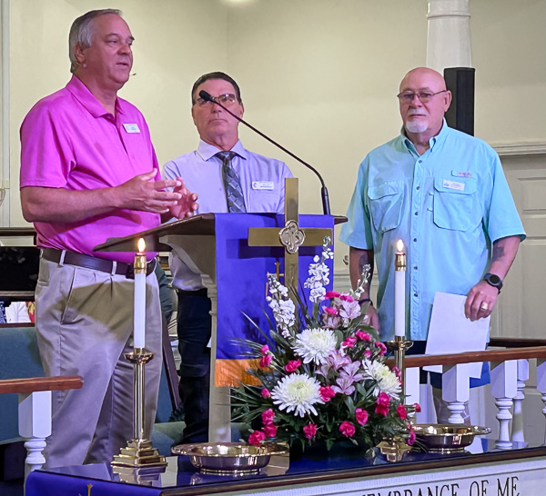 Pastor congratulates two graduates of Lay Leader training.
