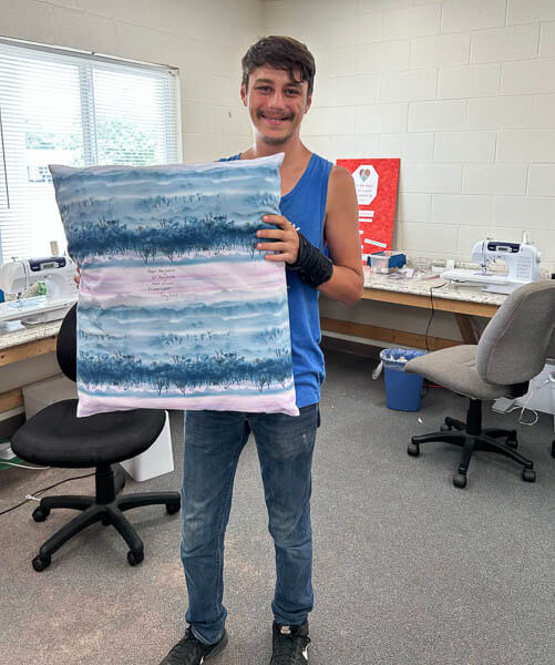 Young man holds custom made pillow