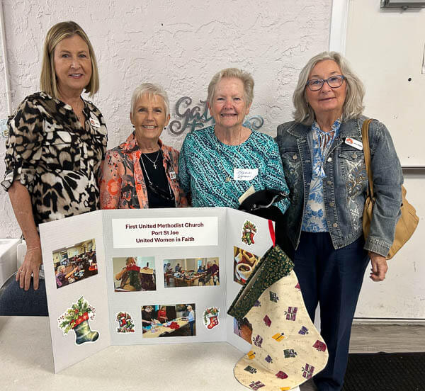 Four women from Port St Joe stand with their poster