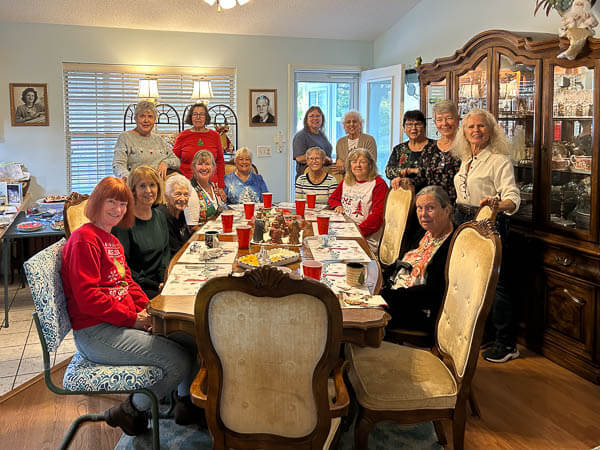 Group of women gather around a beautiful table in a member's home.