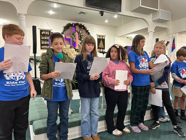 Children read in front of the sanctuary