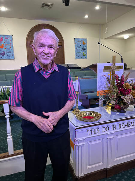 Man stands in front of Communion Table