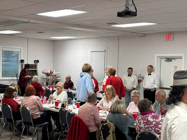 Tables of people eat in the fellowship hall