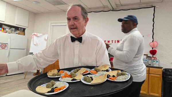 Man serves food with a large tray