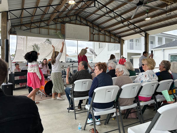 Choir members wave palm branches on Palm Sunday