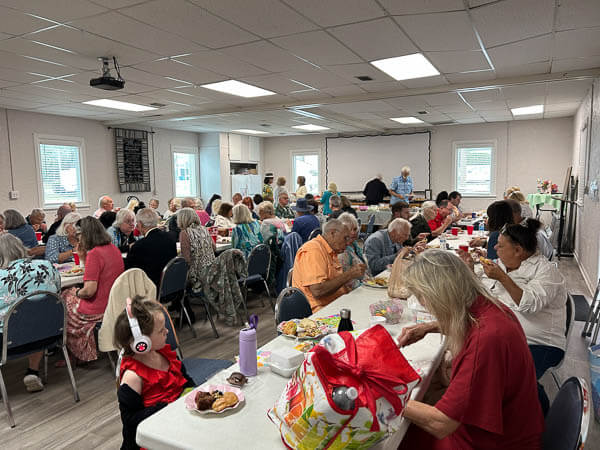 People eat lunch in the Fellowship Hall